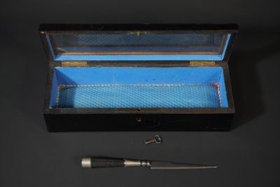 une petite boîte contenant un couteau, posée sur une table