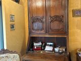 une armoire en bois dans un coin d'une pièce où se trouve un tapis bleu