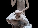 une statue représentant une femme assise sur les genoux d'un homme