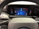 the steering wheel of a car with a digital display in the center