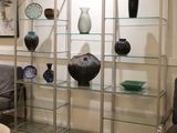 many vases on glass shelves in this room