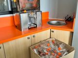 une caisse d'oranges dans une cuisine, à côté d'un évier