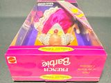 barbie ' s french doll in a pink box on a gray surface