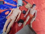 three mannequins on a table with a box and a cell phone