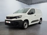 La camionnette blanche est garée dans une grande pièce.