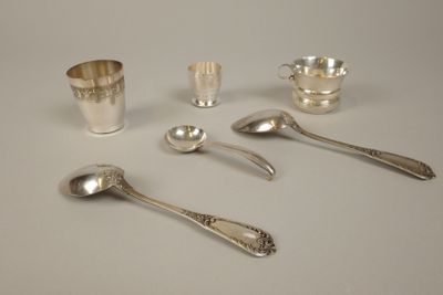 Plusieurs cuillères et tasses sont posées sur une table