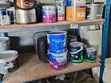 many cans of paint on a shelf in a room