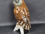 a ceramic owl that is sitting on top of a table