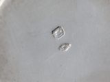 a close up of a silver plate with a small diamond on it