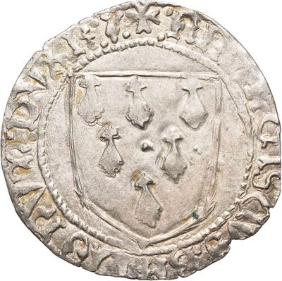 un gros plan d'une pièce d'argent sur laquelle figure un blason