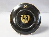 a black and gold plate with a gold crest on it