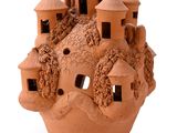 une sculpture en argile représentant un château au sommet d'une colline