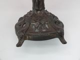 a bronze statue of a woman holding a bird on top of a table