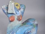 a blue and white figurine of a cat with a fish on its back