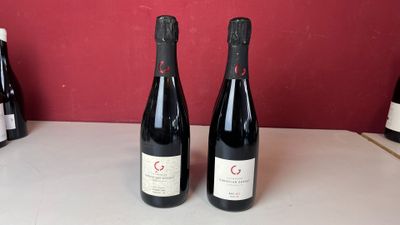 trois bouteilles de vin sont posées sur un comptoir devant un mur rouge
