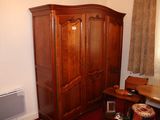 une photo d'un salon avec une grande armoire en bois