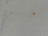 a close up of a piece of fabric with a brown spot on it