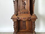 a wooden grandfather clock on a stand in the corner of a room