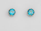 une paire de boucles d'oreilles à clous en cristal bleu sur fond blanc