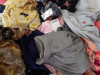 une pile de vêtements posée sur un lit
