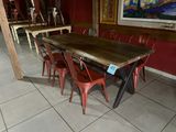 une table et des chaises dans une pièce où est accroché un tableau