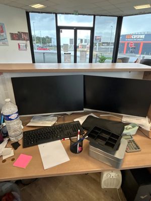 un bureau sur lequel sont posés deux écrans d'ordinateur et un clavier