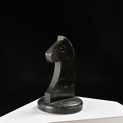 sculpture représentant une tête de cheval sur un socle blanc, sur fond noir