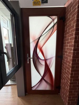 une porte vitrée ornée d'une peinture, à côté d'un mur de briques