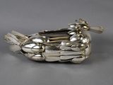 a silver bird shaped dish with spoons on it