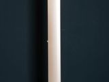 the floor lamp in the corner of a room with a black wall