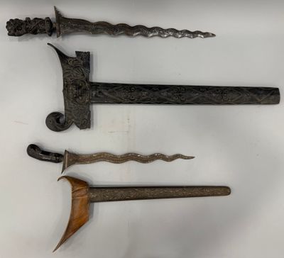 trois types d'armes différents sont exposés sur une surface blanche