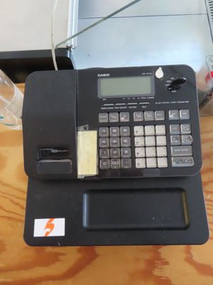 a calculator sitting on top of a desk with a laptop in the background