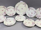 douze pièces de vaisselle en porcelaine rose et blanche sur fond gris