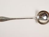 a silver spoon with a spoon handle on a white surface