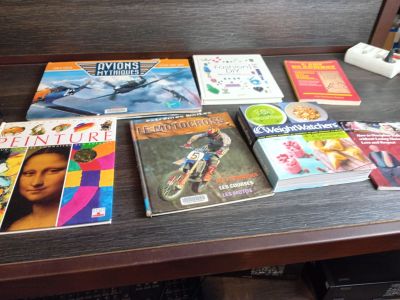 de nombreux livres posés sur un bureau devant un ordinateur