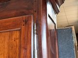 a large wooden cabinet with a door and a clock on top of it