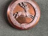 un bouton en bronze orné d'un cerf