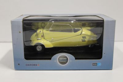 maquette jaune d'une voiture dans une boîte posée sur une surface blanche