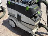 a green and black dust extracter sitting on the ground