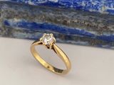 une bague de fiançailles en or jaune sertie d'un diamant au centre