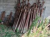 a pile of baseball bats sitting on the ground in front of a building