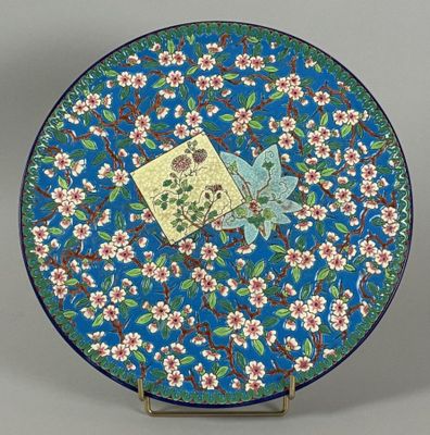 a blue plate with a bird and flowers on it