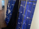 un portant métallique sur lequel sont suspendus des vêtements, dans un couloir
