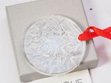 a silver ornament with a red ribbon on it