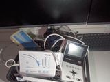 a basket full of electronics on a desk with a computer monitor
