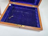 a small wooden box with a key inside of it