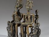 a bronze statue of three people sitting on a bench