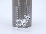 a glass deer figurine that is standing next to a can