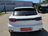 the rear end of a white car parked in front of a building
