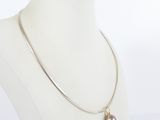 necklace on a mannequin with a pearl and a silver chain